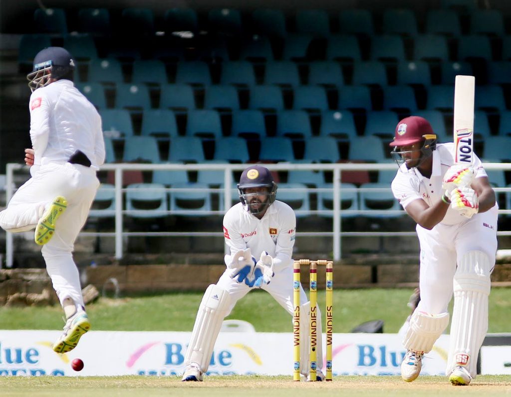 WI skipper Jason Holder drives through the covers on the
 first day  of the first Test against Sri Lanka at the Queens Park Oval, Port of Spain, yesterday.