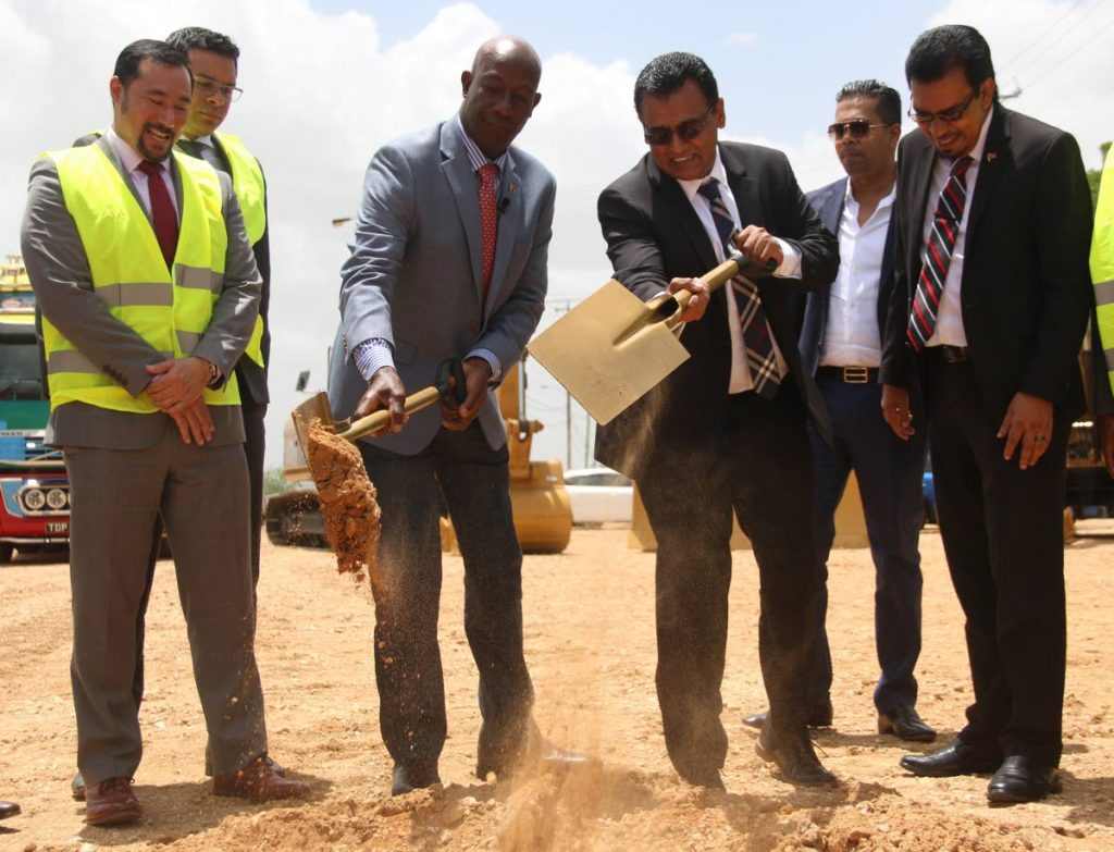 Men at work: Prime Minister Dr Keith Rowley and Works and Transport Minister Rohan Sinanan turn the sod to start work on the Mosquito Creek section of the Point Fortin Highway on Friday, as Communication Minister and Minister in the Offices of the Prime Minister and and Attorney General Stuart Young, left, San Fernando East MP Randall Mitchell, second from left, Local Government and Rural Development Minister Kazim Hosein, right, and contractor Shaun Sammy (second from right) look on. PHOTO BY ANSEL JEBODH