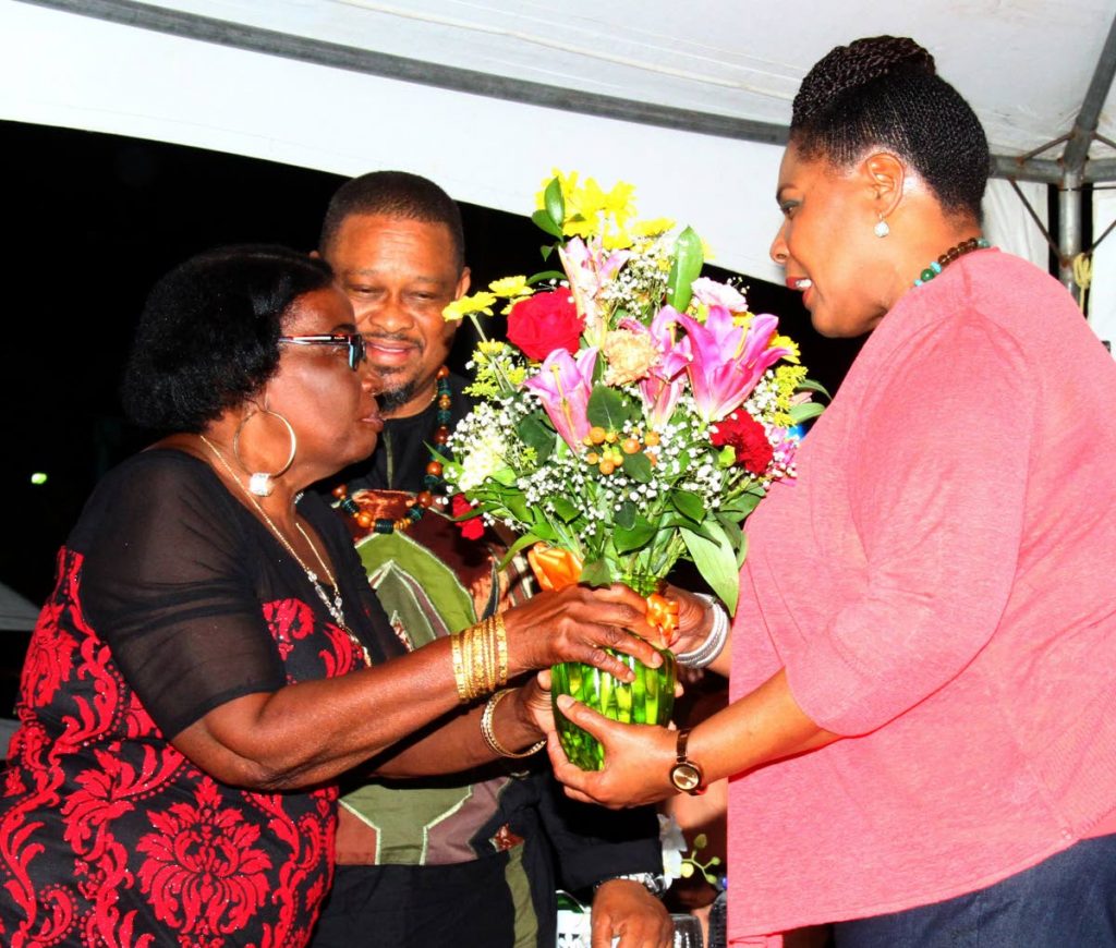 President Paula-Mae Weekes receives a boutique of flowers from Joycelyn Le Blanc, president of Sea Lots Village Council at the launch of i95.5FM’s 2018 Laventille Nights series at the Sea Lots Basketball Court, Port of Spain, on Friday night.