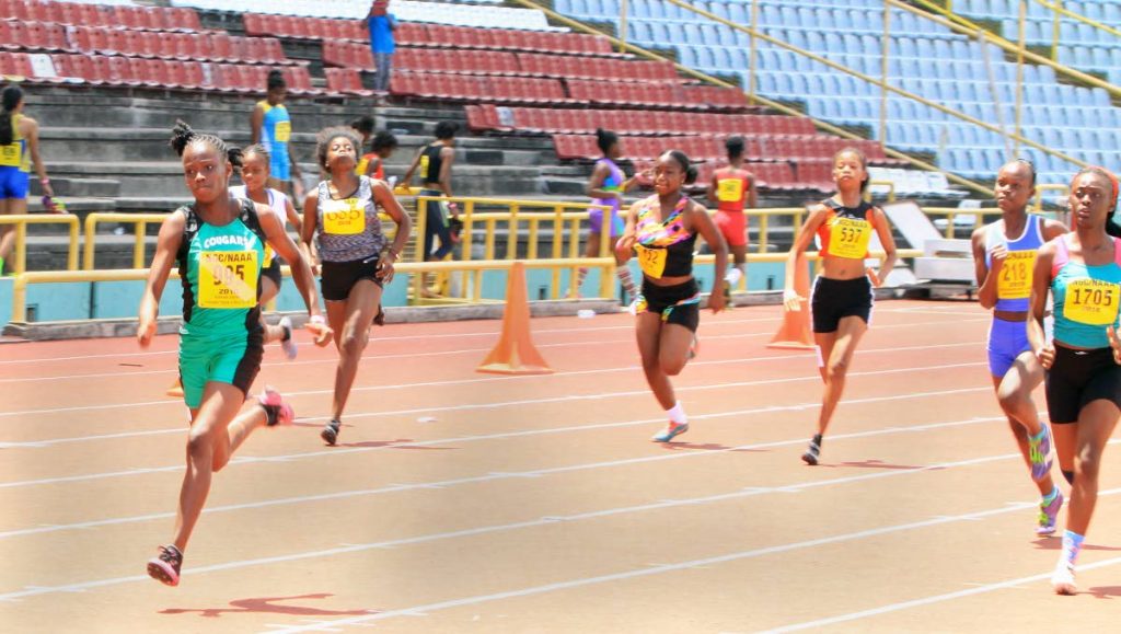 Karessa Kirton,left, wins her heat in the Girls U15 100m, in a time of 12.48 secs, yesterday at the NGC/NAAA Juniour Championships, held at the Hasely Crawford Stadium, Port of Spain.