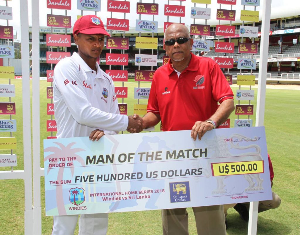 Man-of-the-Match Shane Dowrich, left, collects a cheque from TTCB boss Azim Bassarath on Sunday at the Queen’s Park Oval, St Clair.