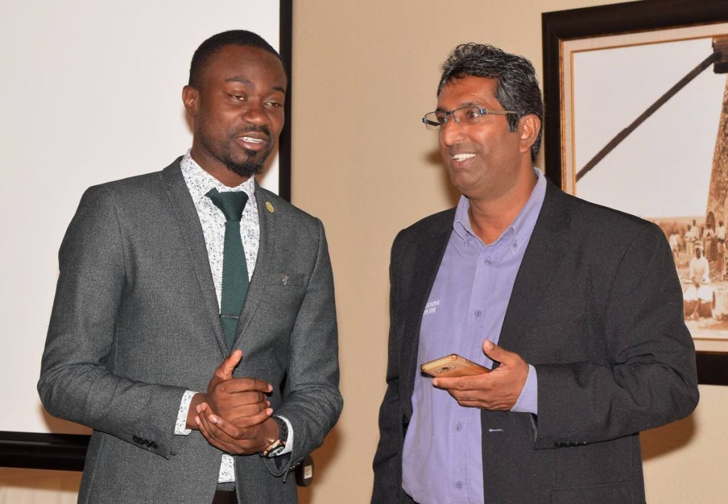 THA Minority representative Farley Augustine, left,  chats with Economist Dr Roger Hosein, Senior Lecturer at UWI, St Augustine at the environment symposium last Thursday at the Mt Irvine Bay Resort.