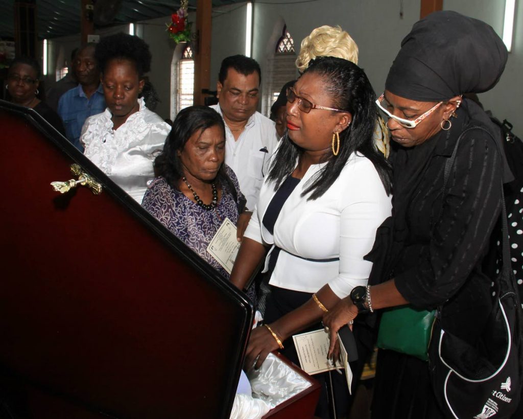 A SISTER’S TEARS: Regan McHutchinson, 2nd from right, weeps near the coffin of her brother Ashdale during his funeral yesterday at the Good Shepherd Anglican Church in Tunapuna. PHOTO BY ANGELO MARCELLE