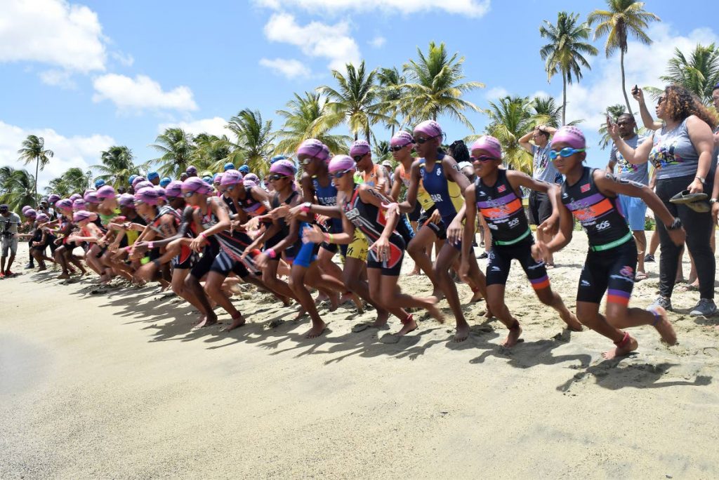 Children run for the water at the start of the 375m swim portion of the 13-15 age group Youth Triathlon at the 14th Annual Massy Rainbow Cup at Courland Bay Heritage Park, Tobago, on Saturday.