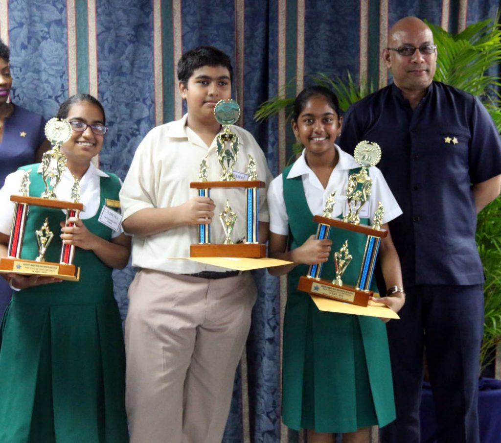 WELL DONE: Amrika Ramlogan, left, Ismail Chinming and Surya Mohammed, right, display their trophies after placing first in the OWTU's primary school Labour Day quiz yesterday at the union's office in San Fernando. PHOTO BY ANSEL JEBODH