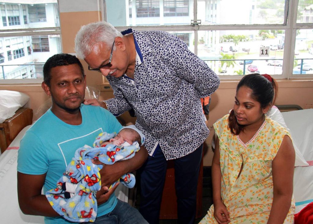 CELEBRATING DADS:Health Minister Terrence Deyalsingh, centre, looks at baby Dawsyn Ramkissoon who is being held by his dad, Dave, left, while mom Nikita Seepersad looks on. Baby Dawsyn was the first baby to be born on Father⁳ Day at the San Fernando General Hospital. The minister was on hand to celebrate fathers at the hospital.