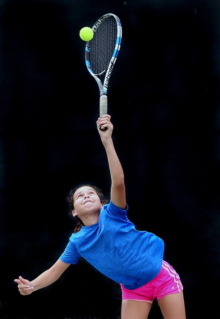 Ella Carrington serves in the Girls U-14 semis at the Lease Operators Junior Tennis, Trinidad Country Club, Maraval, yesterday.
