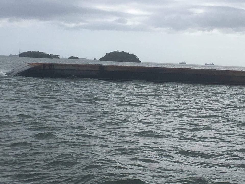 An overturned barge that had been reportedly leaking an oily substance into the Gulf of Paria.
