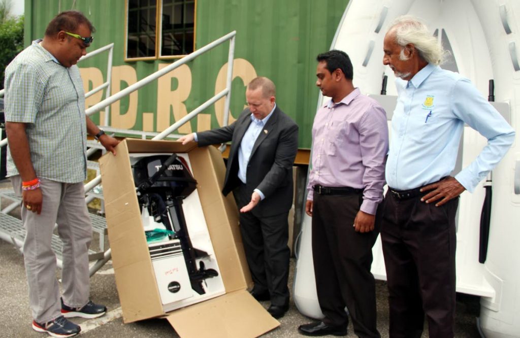 BRAND NEW: US Embassy deputy Chief of Mission John McIntyre, centre, inspects new boat engines donated by the Embassy to the Penal/Debe Regional Corporation yesterday. Also in photo are Alderman Purinshottan Singh, left, Vedesh Lall and corporation chairman Dr Allan Sammy, right. PHOTO BY ANSEL JEBODH