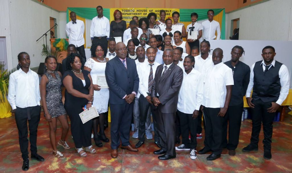Graduates of the Youth Apprenticeship Programme in Agriculture (YAPA) pose for a photo with THA Chief Secretary Kelvin Charles and Secretary of Food Production, Forestry and Fisheries Hayden Spencer, following their graduation ceremony on June 14 at the Glamorgan Community Centre.