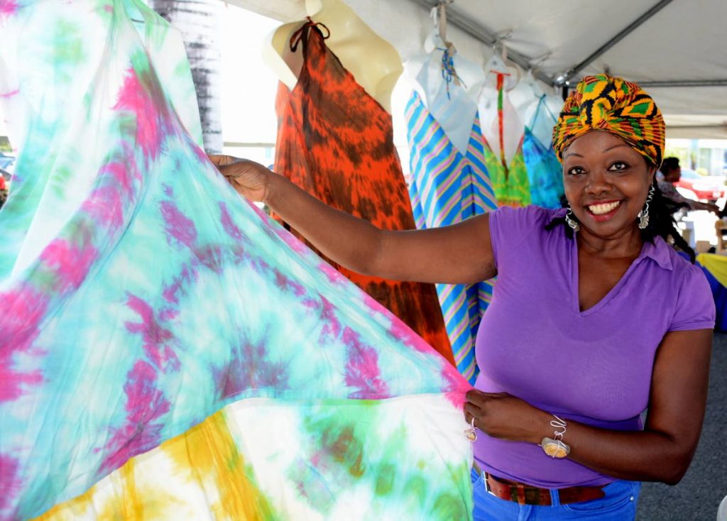 Donna LaRoche, owner of La Roche Unique Designs, shows her creations to a visitor at the Pigeon Point Heritage Park on Tuesday during the closing Emancipation Parade and Drum Explosion event of the Tobago Heritage Festival 2017.