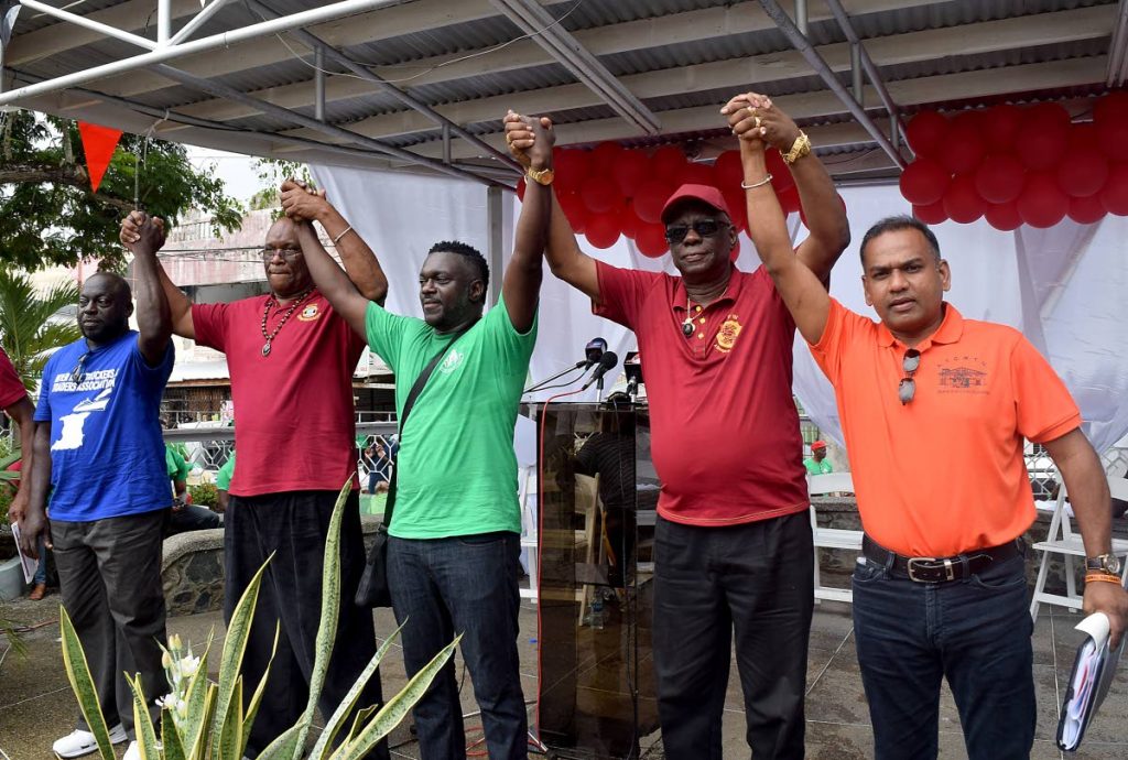 Solidarity: Trade union leaders raise clasped hands in a show of solidarity at Tuesday’s Labour Day rally at James park, Scarborough. From left are Horace Amede, President of the Inter-isle Truckers and Traders Association; Michael Annisette, President of the Seamen and Waterfront Workers Trade Union (SWWTU); Watson Duke, President of Public Services Association (PSA) and the National Trade Union centre (NATUC) Watson Duke; James Lambert, President General of the National Union of Government and Federated Workers (NUGFW) and Nirvan Maharaj, President General of All Trinidad General Workers Trade Union (ATGWTU.