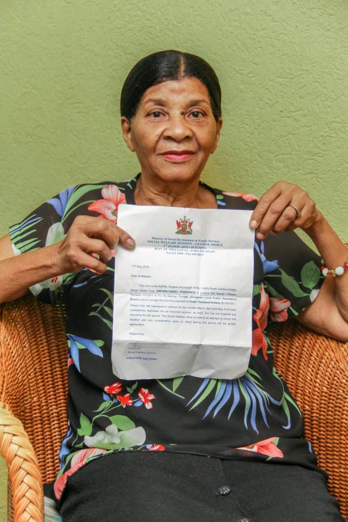 HARDSHIP: Instead of a pension cheque, something she has not seen in over five months, Angela Carasquero shows a ministry document yesterday when she visited Newsday to complain of not being paid her dues since January. PHOTO BY JEFF K. MAYERS