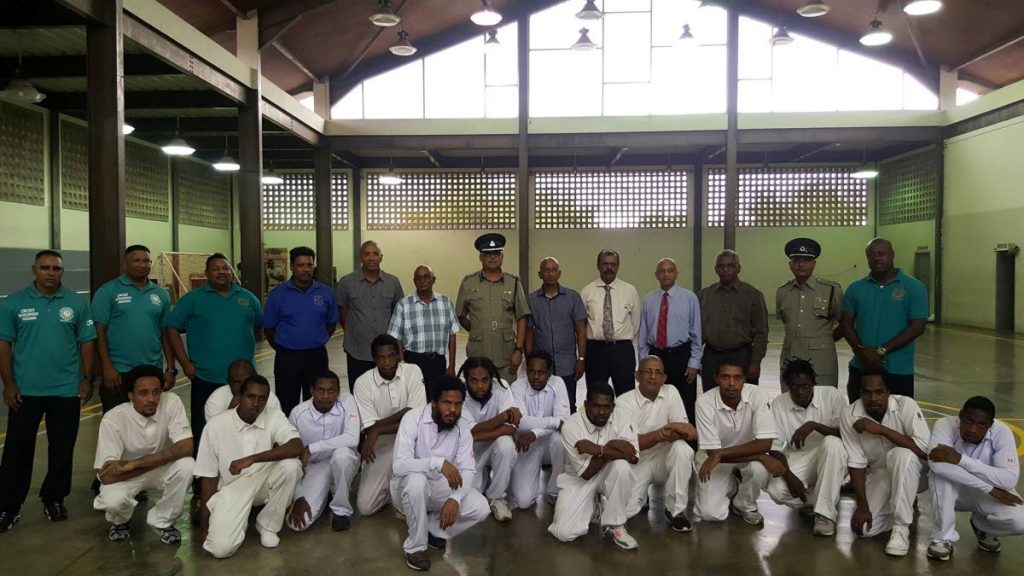 Prison officials, TT cricket officials and members of the inmate cricket team pose at the launch of the Inmate Cricket Development Programme at the Maximum Security Prison in Arouca on Monday.