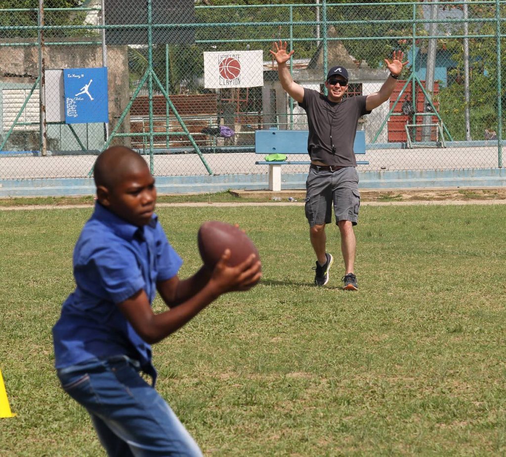 

Good catch: A boy catches the ball in a game of American football with Alex Kenna of the Civil Affairs Unit, US Embassy at Enterprise Recreation Ground, Enterprise.