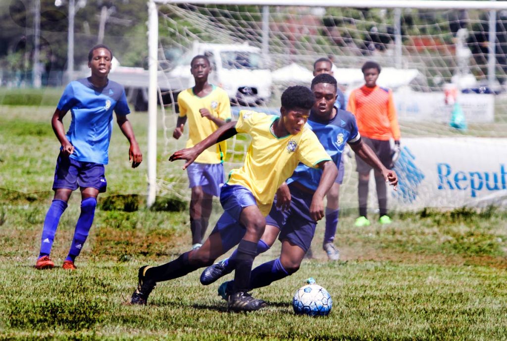 Moziah Findley, right, of FC Santa Rosa vies for the ball against Obi Edwards of Giving Back SA during action, on Saturday, in the Republic Bank Youth League U16 Division at the Queen's Park Savannah.