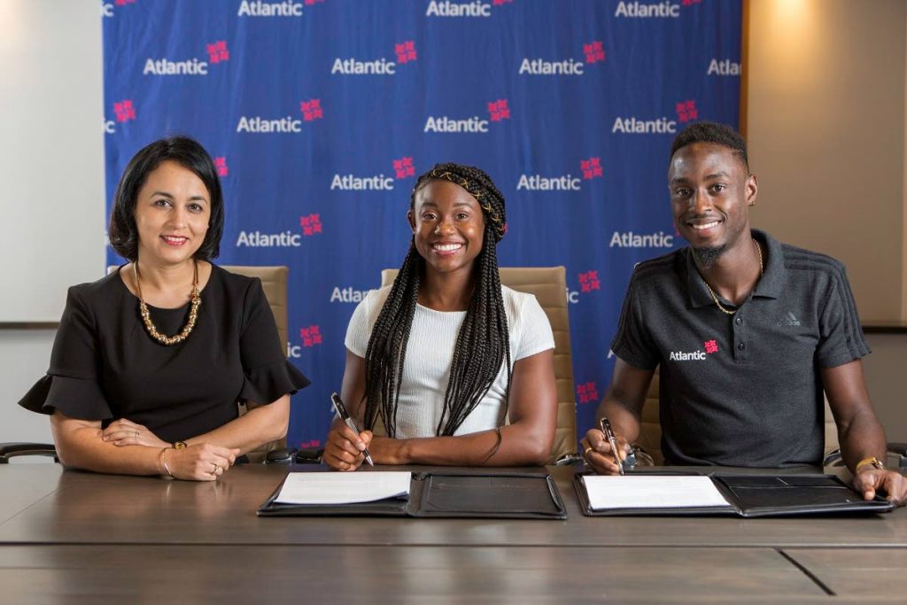 Toni Sirju-Ramnarine (left), Atlantic’s vice-president of Corporate Operations with newly signed Atlantic Sports Ambassadors Khalifa St Fort and Jereem Richards.