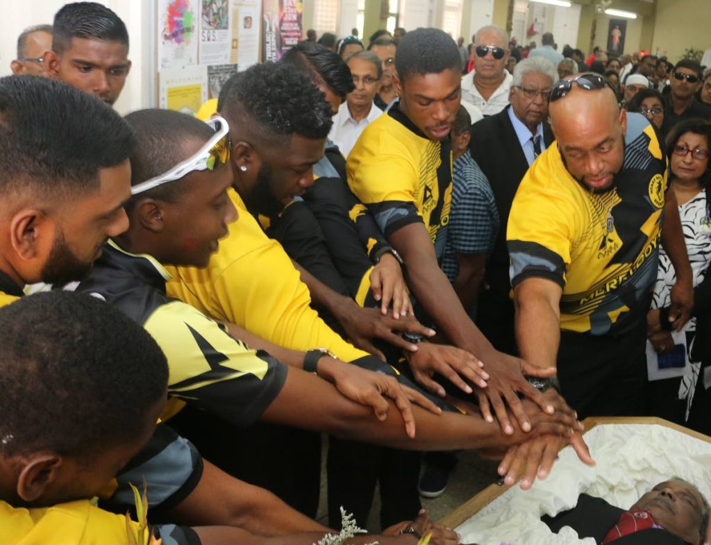 Players and officials of Diego Martin-based Merry Boys cricket club pay their respect to the club's former president Patrick Rampersad at his funeral yesterday held at Church of Nativity, Diego Martin. 