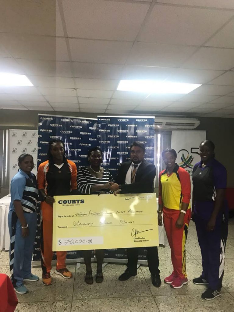 Communications and public relations manager at Unicomer, Fazad Mohammed, third right, presents vice-president of the TT Women's Cricket Association Ann Browne-John,third left, with a sponsorhip cheque at the launch for the Courts T20 Grand Slam tournament, on Wednesday.From left , cricketers Anisa Mohammed and Stacy-Ann King while cricketers Merissa Aguilleira,second right and Lee Ann Kirby, right look on.