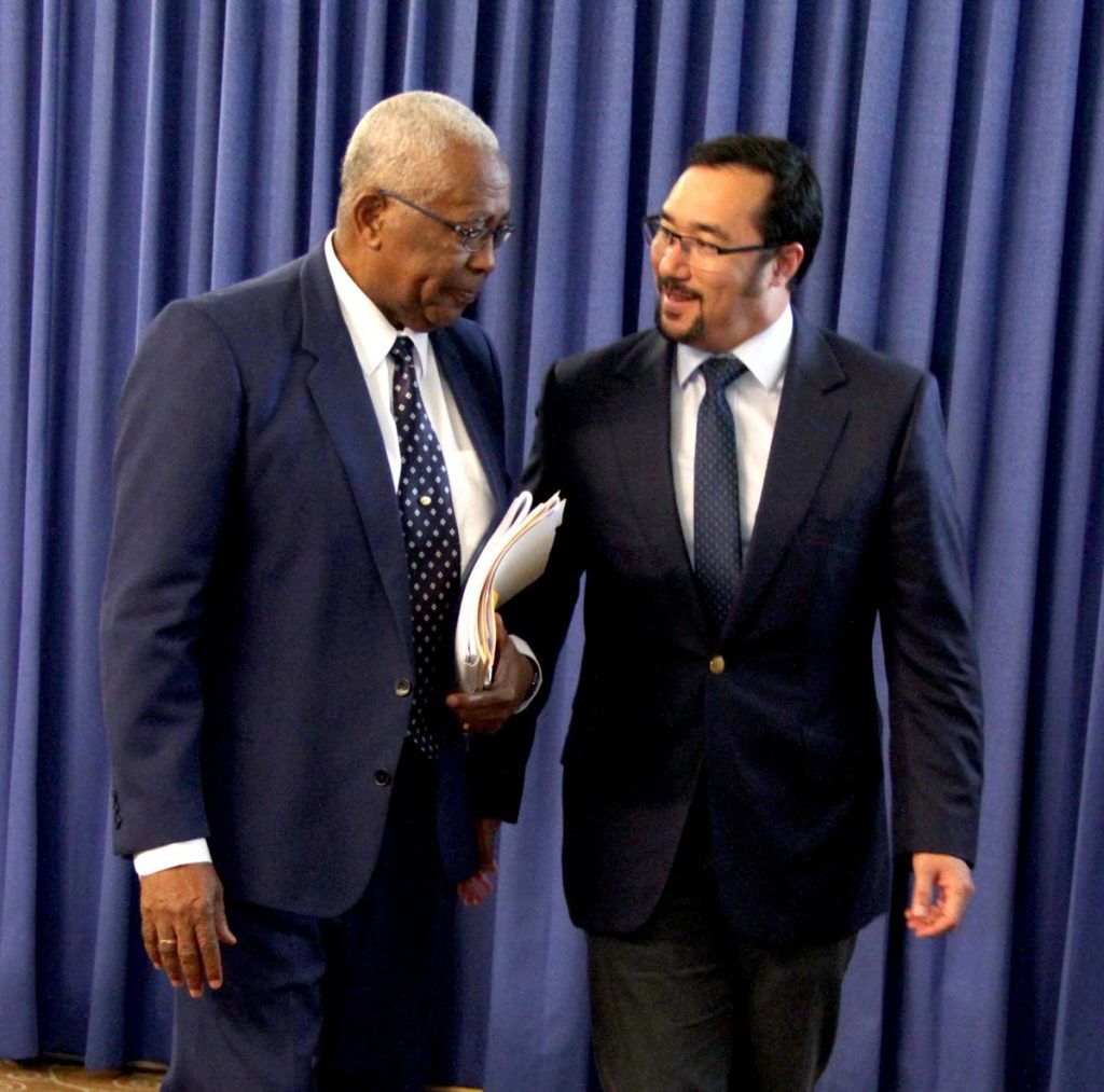 IS IT ME?: Education Minister Anthony Garcia speaks with Communications Minister Stuart Young at yesterday’s post-Cabinet news conference at the Diplomatic Centre in St Ann’s.