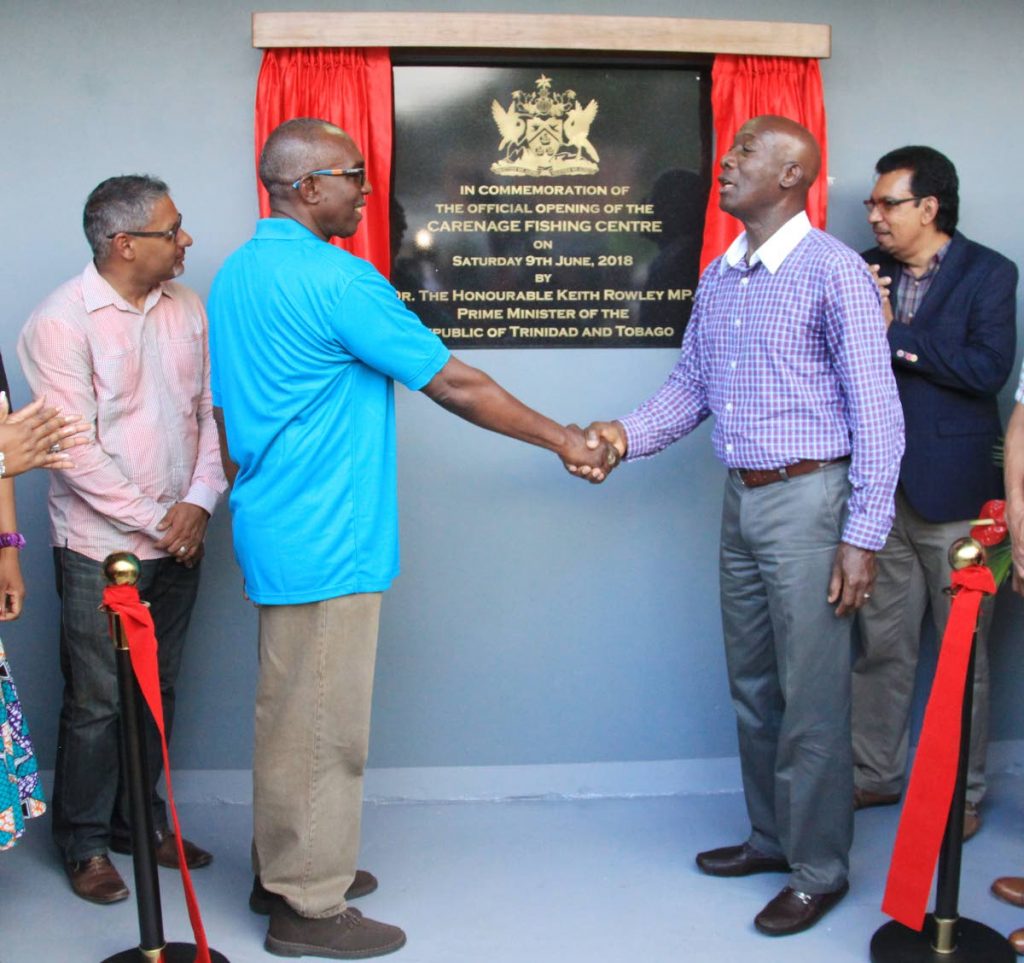 Prime Minister Dr Keith Rowley, right, congratulates Carenage Fisherfolk Association president Robert Millington at the opening of the Carenage Fishing Centre on June 9. Minister of Agriculture Clarence Rambharat, left, and Minister of Rural Development and Local Government Kazim Hosein look on. Rambharat on Friday said the facility is expected to open to the public soon. PHOTO BY ANGELO MARCELLE