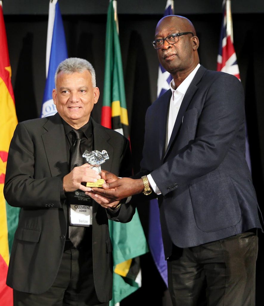 Joseph Remy, vice president of the Caribbean Confederation of Credit Unions (CCCU), right, presents a long-service award to Clement Usher, at the 61st annual international convention of the CCCU at the Hyatt Regency, Port of Spain, on Saturday.