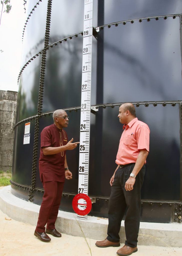 At Left Minister of Public  Utilities Robert Le Hunte chats with WASA head operations north Glason Gurusargnsingh whre they view the newly Installed 100,000 gallons storage tank at Honlolo Cascade
PHOTO BY AZLAN MOHAMMED