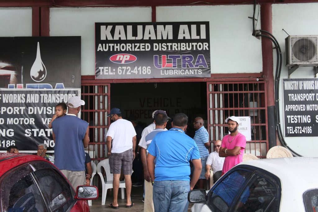 Vehicle owners stand in line to process their inspection certificates at Kajim Ali  vehicle testing station on Monroe Road, Chaguanas yesterday. PHOTO BY AZLAN MOHAMMED