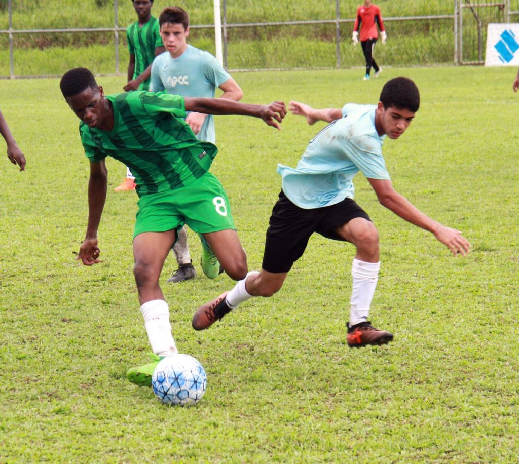 A Petit Valley/Diego Martin player, left, competes against a Queen's Park opponent in a Republic Bank Youth League semifinal at Manny Ramjohn training field, Marabella, yesterday. 
PHOTO BY ANIL RAMPERSAD.