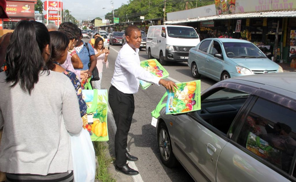 FOR YOU: Massy Stores marketing head Anthony Choo Quan hands out reusable bags to motorists in St Augustine last July.