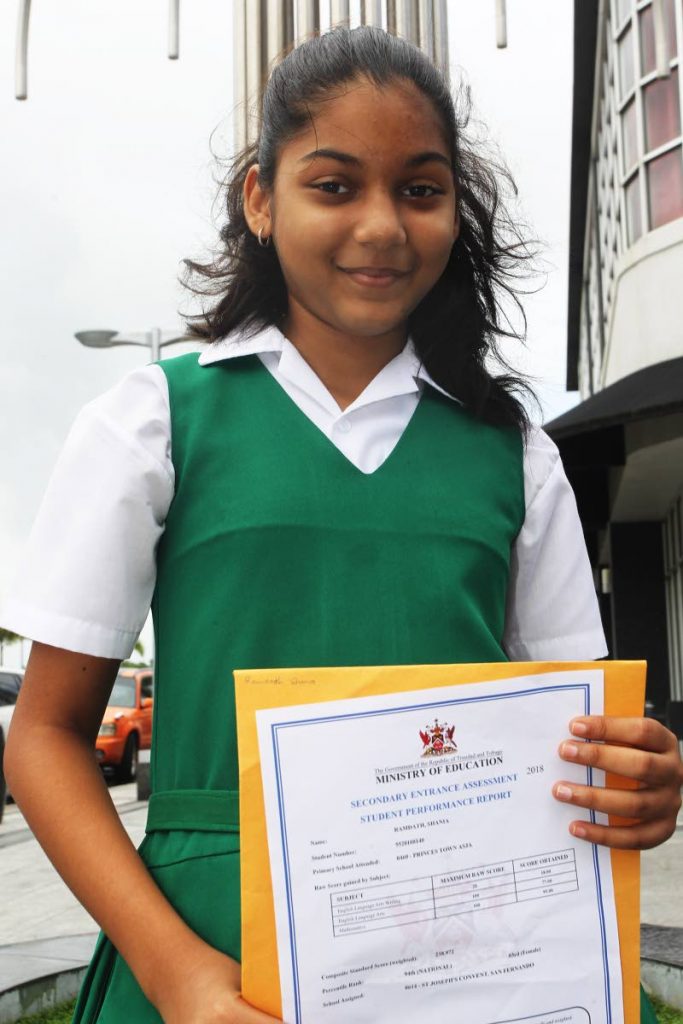 NEW BEGINNING: Shania Ramnath smiles proudly as she displays her SEA result yesterday.  Her mother Anita Ramnath died in a fire which destroyed their Princes Town home almost two months ago.