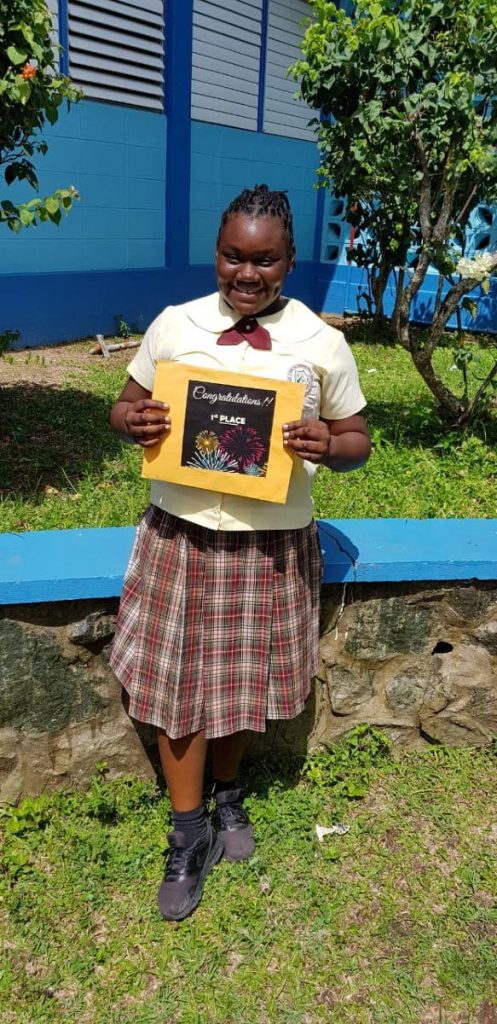Da-xia Ayari Lii James, of Signal Hill Government Primary School, poses with her congratulatory card at the school on Wednesday.
Photo courtesy Dale James