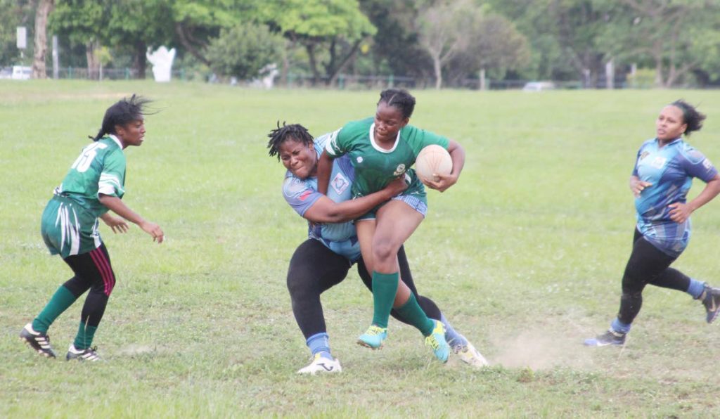 Police’s Abygail Lewis,left, tackles Makella Jones,right, of Harvards  in the final of the first leg of a five-part TTRFU-sanctioned Women’s Division tournament, on Saturday. Police won the first leg with a win over Harvard in the final at the Queen’s Park Savannah, Port of Spain.