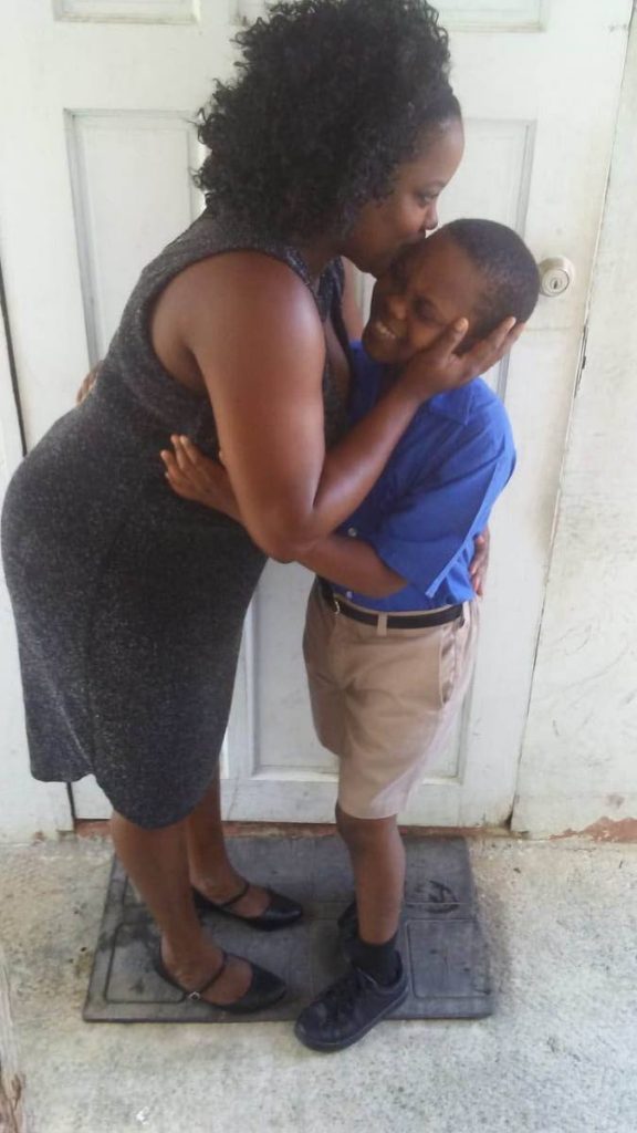 HAPPINESS: Visually impaired Jaidon Vincient, 12  is smothered  by his mother Latoya Tannis, 36. Jaidon was successful in the SEA examination  and will attend Debe Secondary school.