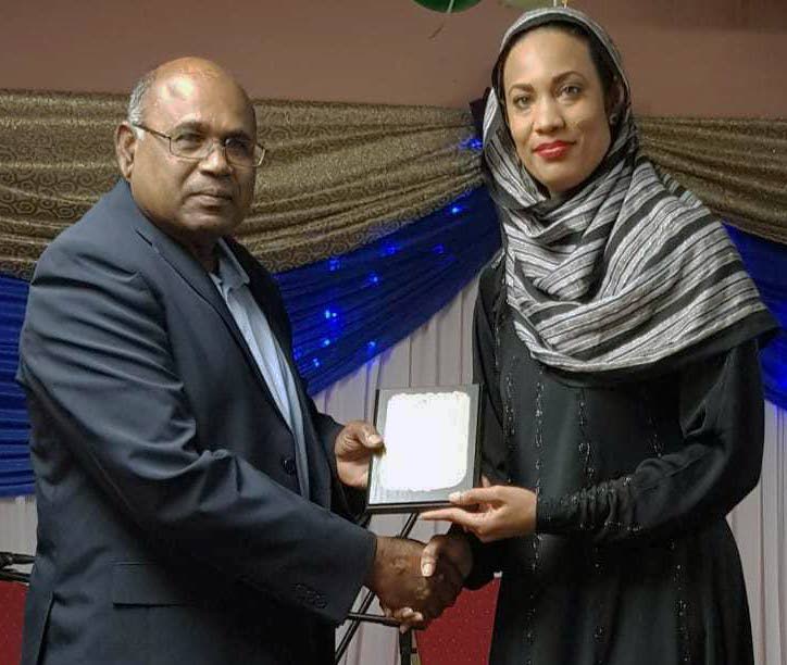 AWARD: Veteran freelance journalist Ramdeo Heeralal receives his award from Opposition Senator Khadijah Ameen at the Ummah TT Eid dinner and awards ceremony at the Felicity Diplomatic Centre.