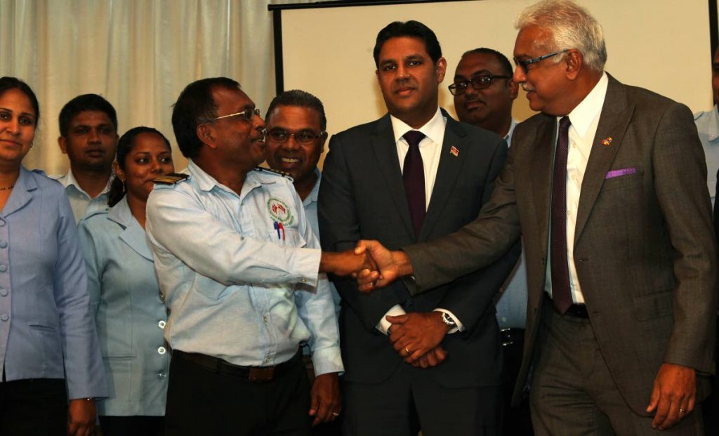 Christopher Saith, public health inspector IV, shakes the hand of Minister of Health, Terrence Deyalsingh while Chief Medical Officer Ministry of Helath, Dr Roshan Parasram look on, following the Ministry of Health Inter-Agency Media Conference on the state of readiness for the 2018 rainy season.