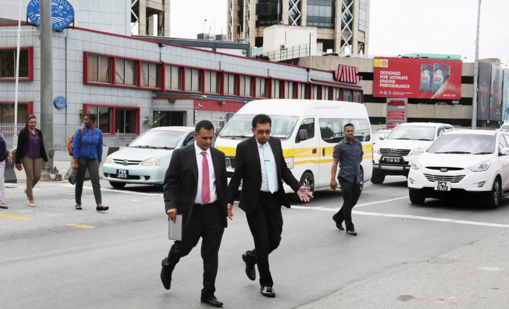 WALKING THE WALK: Minister of Works and Transport Rohan Sinanan (left) and Local Government Minister Kazim Hosein use the zebra crossing to get from the Brian Lara Promenade to the International Waterfront Centre at Wrightson Road, Port of Spain on Wednesday.

Photo by Azlan Mohammed