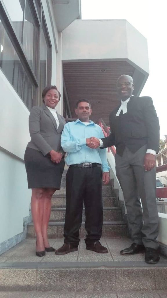 Freed Bobby Ramlogan stands between his attorneys  Cedric Neptune and  Marissa Bobb outside the  San Fernando High Court. 