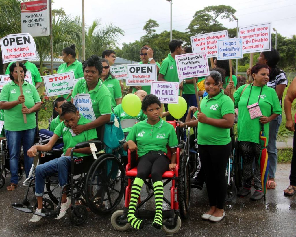 PROTEST: Parents with their physically challenged children protest yesterday for the opening of the newly built Centre for Persons with Disabilities, Chase Village, Carlsen Field. PHOTO BY VASHTI SINGH