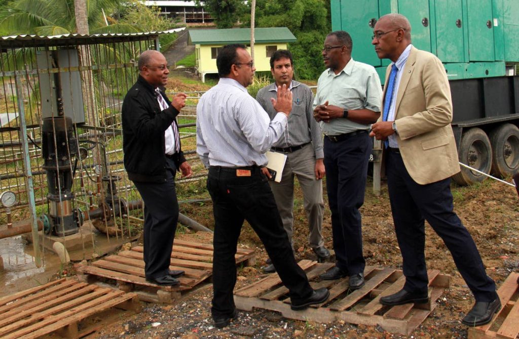 Public Utilities Minister Robert Le Hunte (right) and Point Fortin MP Edmund Dillon chat with WASA officials during a visit to the newly-installed water booster pumping station at Bamboo Junction, Cedros on Friday.