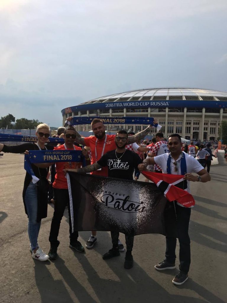 TTFA’s director of communications Shaun Fuentes (right), poses with the national flag alongside fellow Trinis Sham, (second from left) and Armis Mohammed (centre) and Russian friends Elena  (left) and Andrew Mischenko outside the Luzhniki Stadium in Moscow before Sunday’s World Cup final.