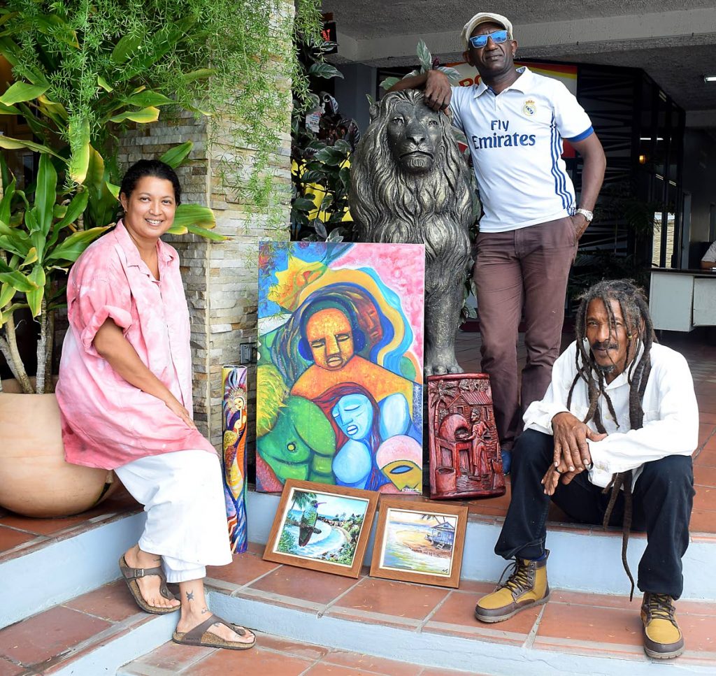 From left, Jeannine Lethe Crouth, Chris Thomas and Joseph Bacchus show of some of the art pieces which would be on show in the exhibit, Melee and Mythos in Tobago Lore, at the Shaw Park Cultural Complex from July 22. Photo by Vidya Thurab