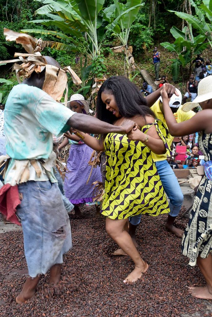 Sports Minister and MP for Tobago West, Shamfa Cudjoe, right, dances the cocoa at Natural Treasures Day in Charlotteville on Monday.

