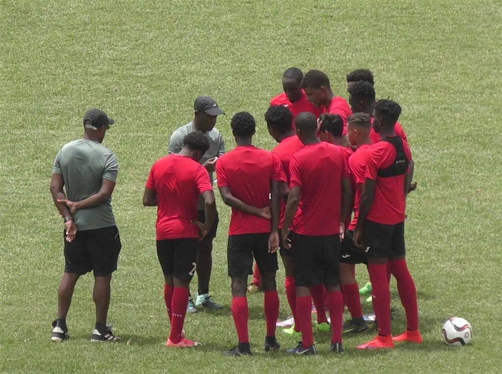 National Under-20 coach Russell Latapy, centre, talks to his players following a training session recently. 