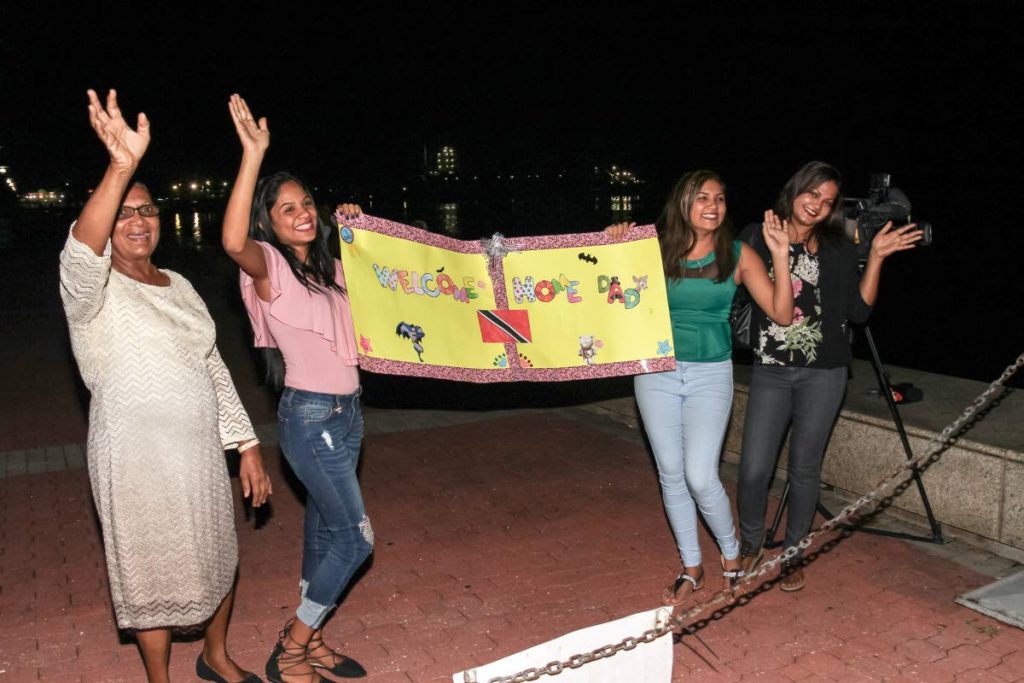 WELCOME HOME: Krystle Khan, right, her mother in law Madonna Khan, left, and Krystle’s daughters Aenea, 2nd from left, and Alisha await the arrival of their loved one, Galleons Passage captain Allister Khan on Monday night at the the International Waterfront Centre in Port of Spain. PHOTO BY JEFF K. MAYERS