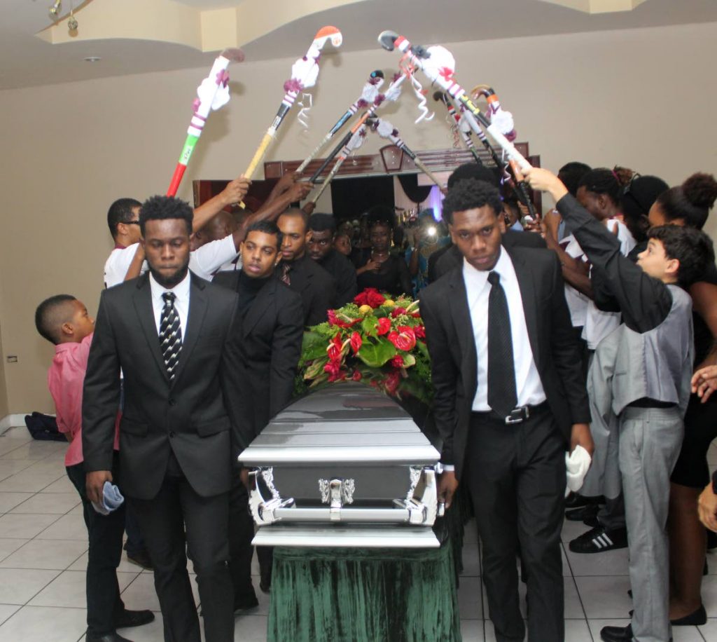 The brothers of Kwasi Emmanuel, Keiron, left, and Kristien, right, carry his casket at his funeral service at Faith Assembly Church yesterday in Five Rivers. PHOTO BY ENRIQUE ASSOON