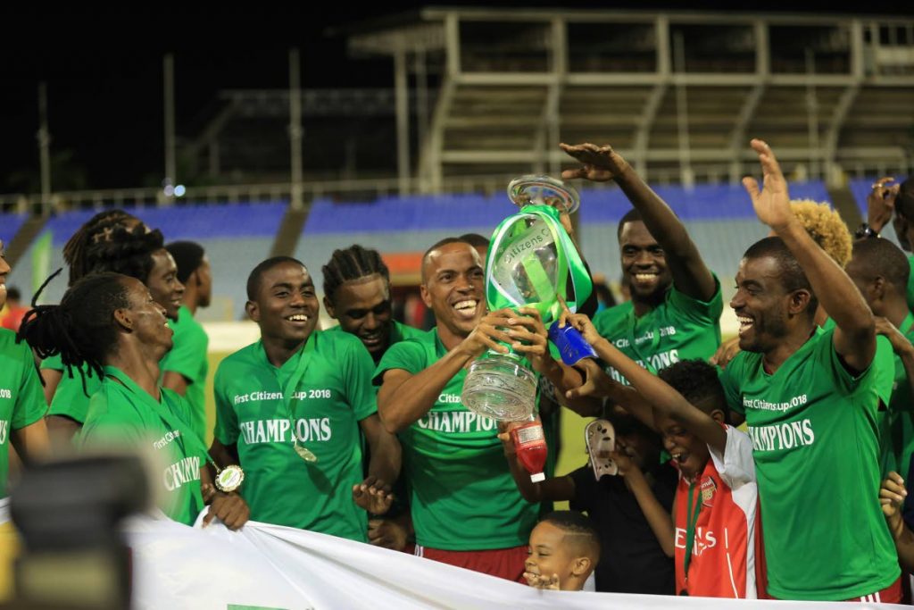 Central FC captain Densill Theobald, centre, lifts the First Citizens Cup trophy as teammates celebrate around him after Friday's final vs Defence Force at the Hasely Crawford Stadium, Mucurapo.