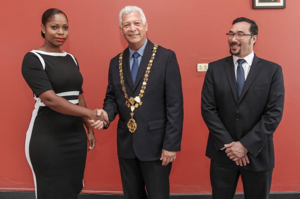 A YOUNG THING: New councillor for Belmont East Nicole Young is welcomed to the PoS city council by mayor Joel Martinez while PoS North / St Ann’s West MP Stuart Young looks on.  
 PHOTO BY JEFF K. MAYERS