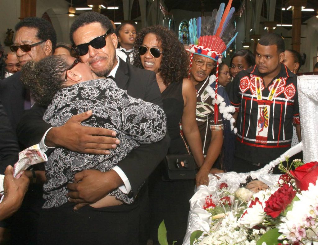 TEARS: Vanessa Cassar Blakely and John Cassar console each other at the coffin of their mother, Carib Queen Jennifer Cassar at the Santa Rosa RC Church yesterday. PHOTOS BY ANGELO MARCELLE