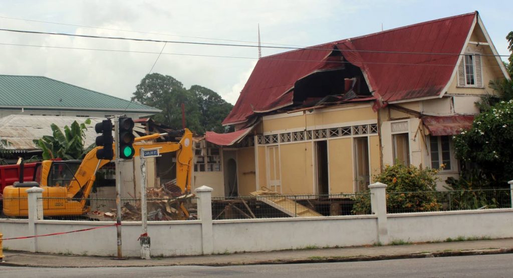 A crew tore down the garage and an annex before removing the roof of a Gingerbread house on the corner of Carlos Street and Ariapita Avenue in Woodbrook. PHOTO BY ENRIQUE ASSOON